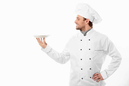 Young cook holding an empty plate on a white backgroundの写真素材