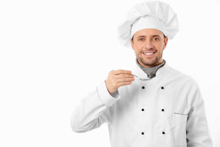 Mature cook with spoon on white backgroundの写真素材