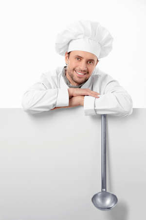 Mature cook with a ladle on a white backgroundの写真素材
