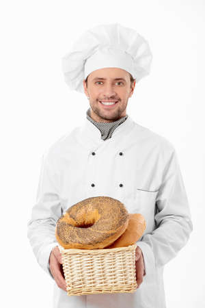 Cook holds a basket of bread on a white backgroundの写真素材