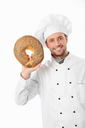 Cook holds a loaf of bread on a white backgroundの写真素材
