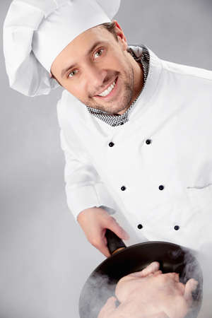 The cook prepares a hen in a frying panの写真素材
