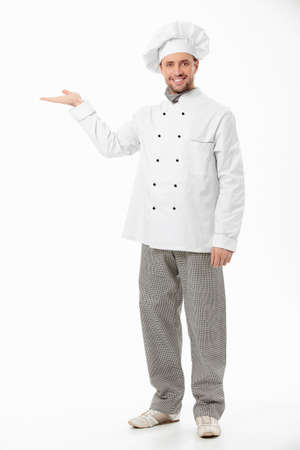A smiling cook shows his hand on a white backgroundの写真素材