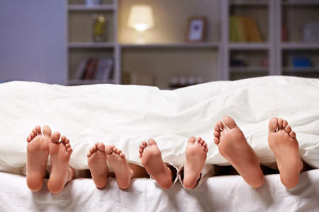 Feet sticking out from under the blanketの写真素材