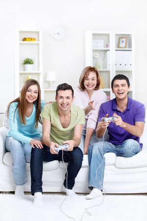 Young beautiful friends play video games at homeの写真素材