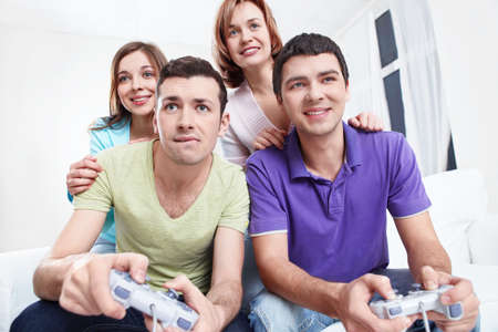 Young  friends play video games at homeの写真素材