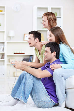 Happy friends play video games at homeの写真素材
