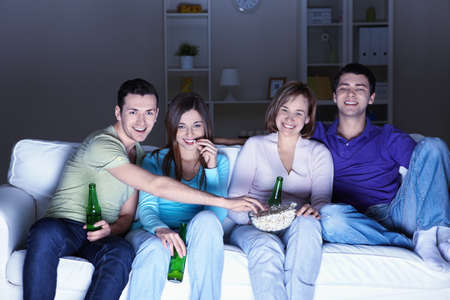 Young people watch TV at homeの写真素材