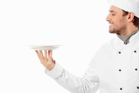 A smiling cook looks at the empty plate on a white backgroundの写真素材