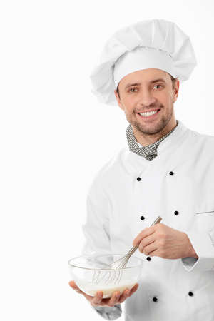 A young cook mixes on a white backgroundの写真素材