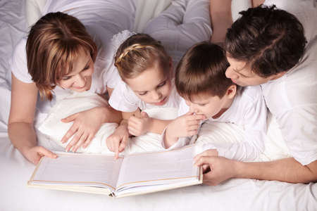 Parents of children reading a bookの写真素材