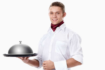 The young waiter with a tray covered with a dome on a white backgroundの写真素材