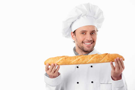 A young baker holds a loaf on a white backgroundの写真素材