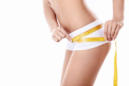 Young girl measuring hip on a white backgroundの写真素材