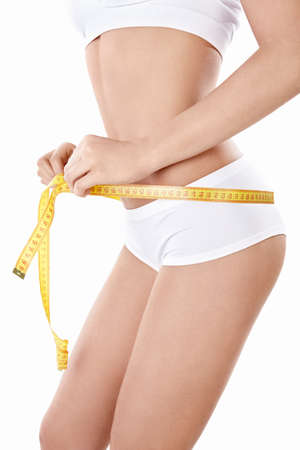 Young girl measuring thigh on a white backgroundの写真素材