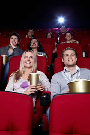 Smiling people are watching movies in cinemaの写真素材
