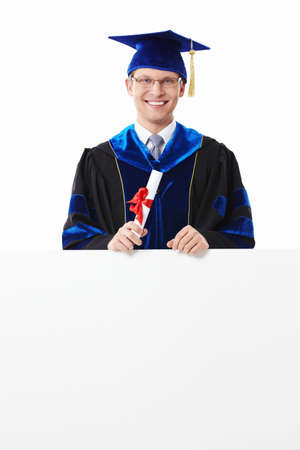 Young student with a diploma with an empty billboard on a white backgroundの写真素材