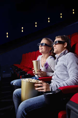 Young couple watching a movie in the cinemaの写真素材