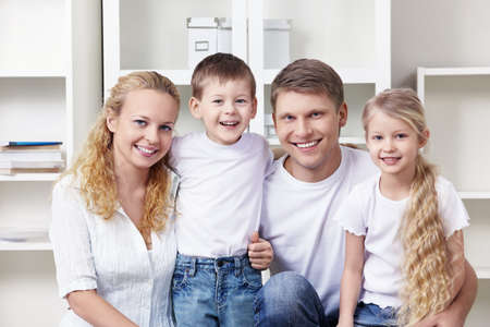 A happy family with two children at homeの写真素材