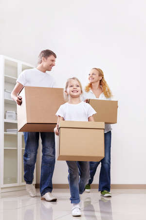 Parents and daughter are cardboard boxes indoorsの写真素材