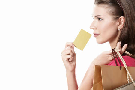 Young girl with a credit card and shopping bags on white background