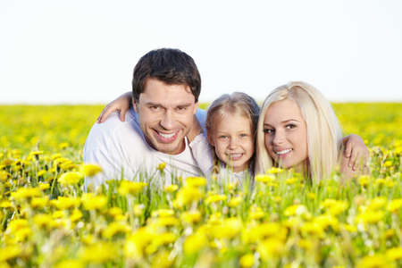 Happy young family in the dandelion fieldの写真素材