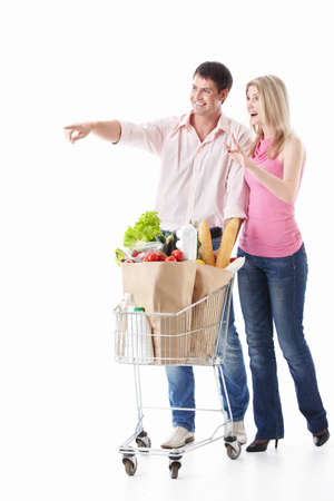 The happy couple with a cart with food on a white backgroundの写真素材