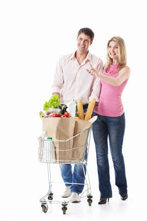 The happy couple with a cart with food on a white backgroundの写真素材