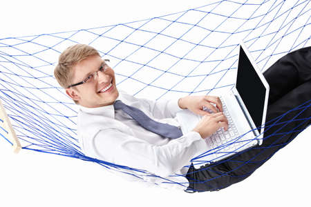 Businessman in a tie with a laptop in a hammock isolatedの写真素材