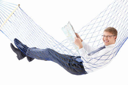 Young businessman with a map in a hammock isolatedの写真素材