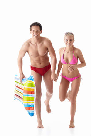 Running a young couple in bathing suits isolatedの写真素材