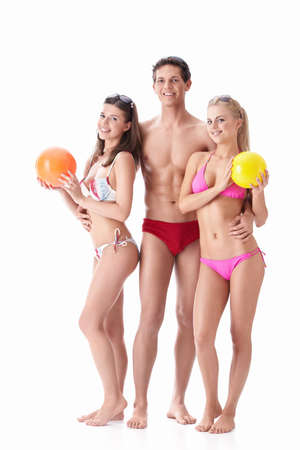 Young people in bathing suits with balls on a white backgroundの写真素材