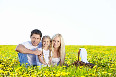 Happy young family in the dandelion fieldの写真素材