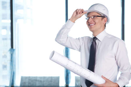 A young man in a shirt and a helmet on a construction siteの写真素材
