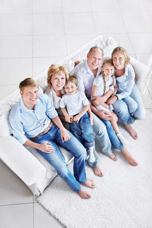 Happy family with children and grandchildren on the couchの写真素材