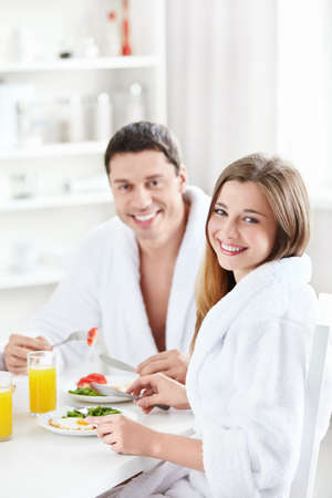 Young happy couple at breakfast in the kitchenの写真素材