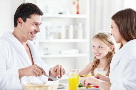 Happy family at breakfast in the kitchenの写真素材