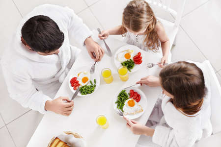 Happy family at breakfast in the kitchenの写真素材