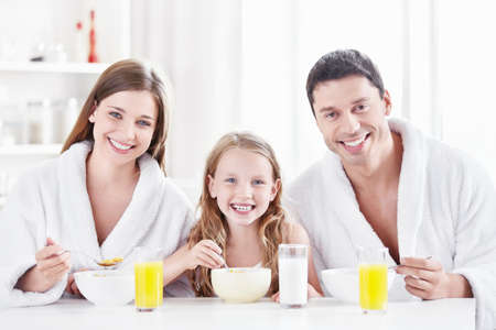 A happy family with a child in the morning in the kitchenの写真素材
