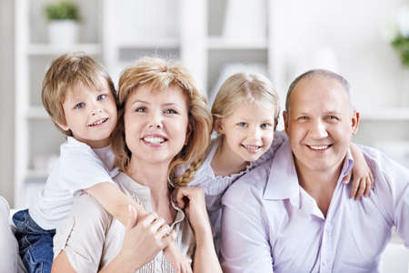 Happy mature couple with grandchildrenの写真素材