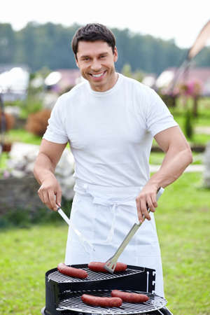 Smiling man with a barbecueの写真素材