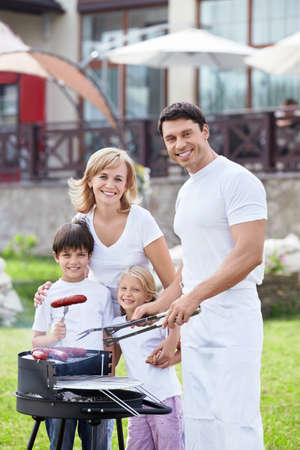 Happy family with children at barbecueの写真素材