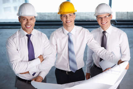 Business people in hard hats at construction siteの写真素材