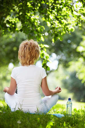 A woman practices yoga outdoorsの写真素材