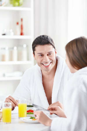 Attractive young couple eating breakfast in the kitchenの写真素材