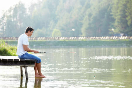 A man fishing on the bridgeの写真素材