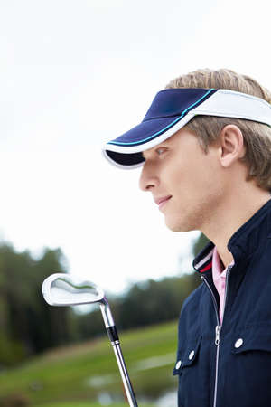 A young man with a golf clubの写真素材