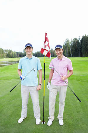Two players at the hole on the golf courseの写真素材