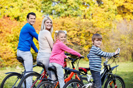 A young family with children on bicyclesの写真素材