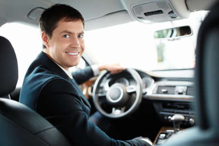 Man in a suit driving a car